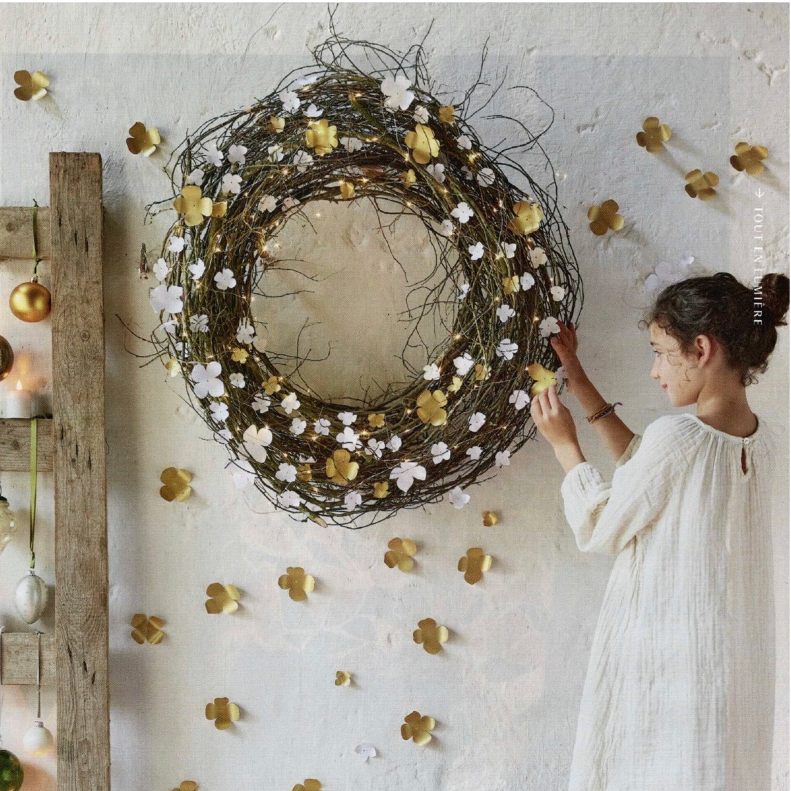 couronne faites de branches et décorée de fleurs en papier doré