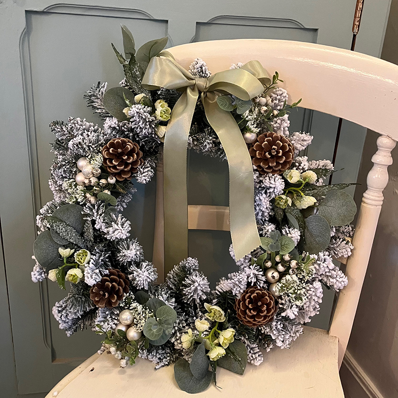 couronne de sapin avec fleurs et ruban