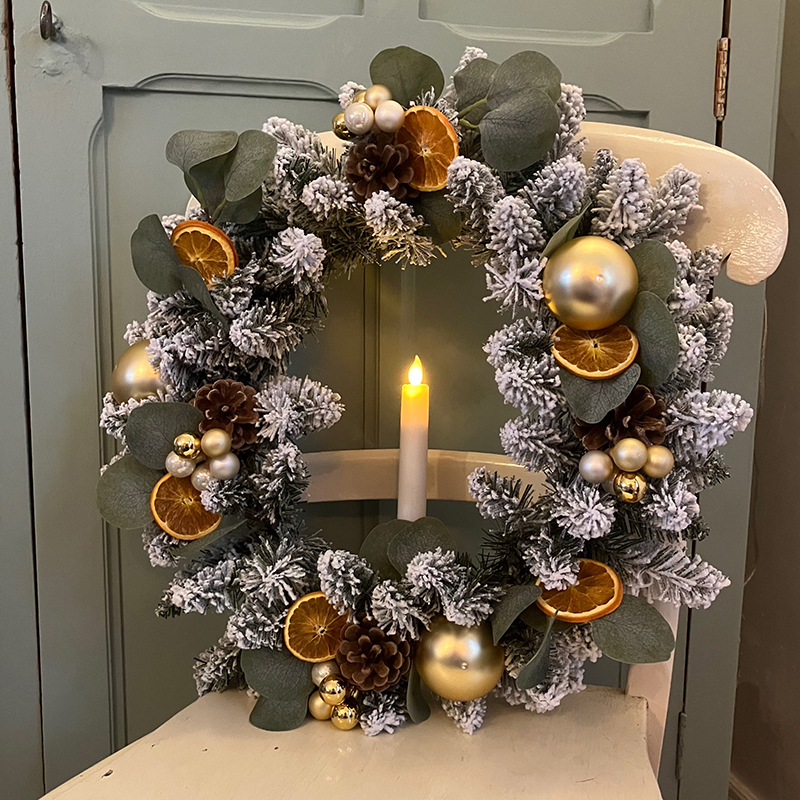 une chandelle électrique dans une couronne de Noël