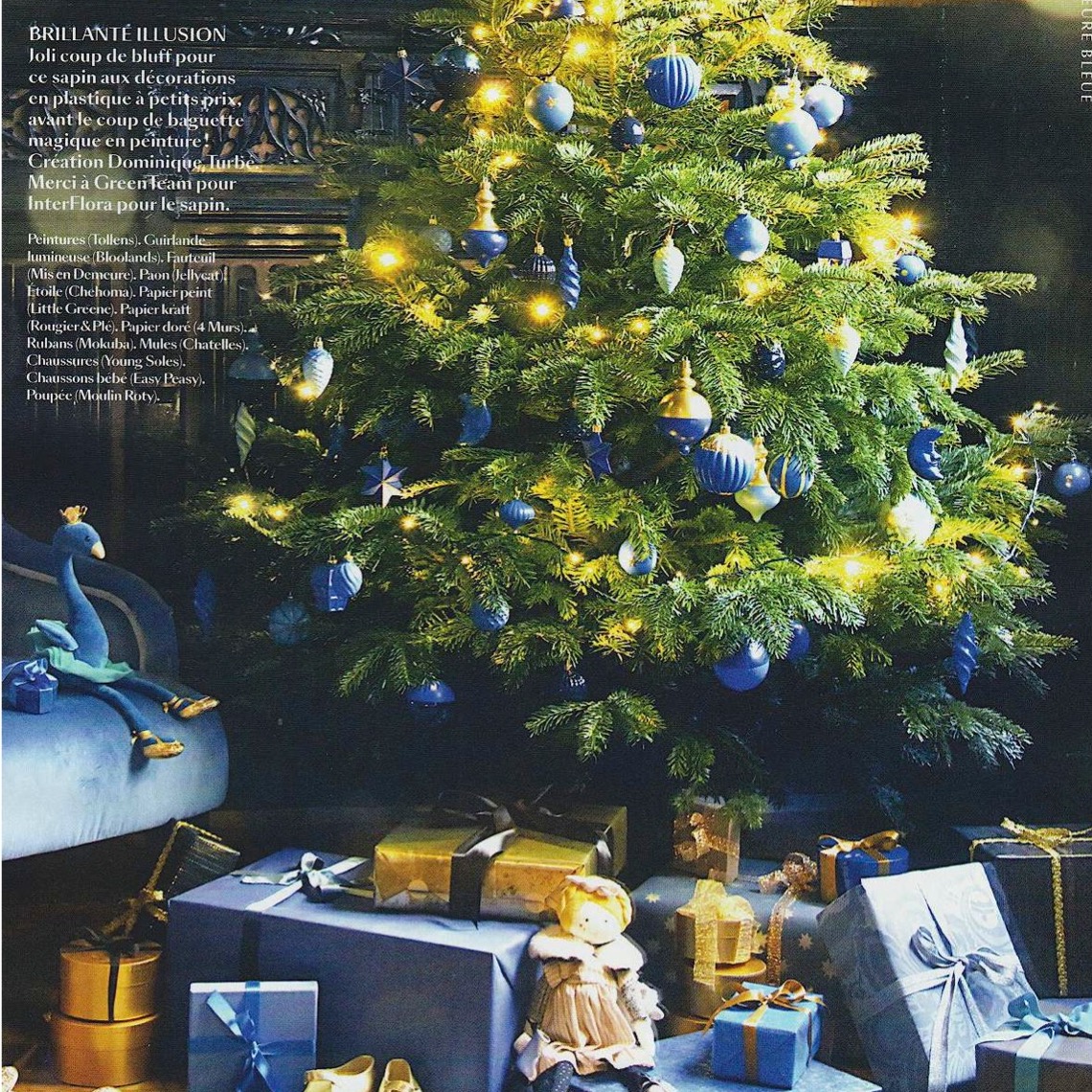 un sapin aux décorations bleues et illuminé d'une guirlande Led Or