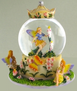 Schneekugel mit Spieluhr aus Polystone : glitzernde Schneekugel mit Spieluhr und Fee und Blumen.