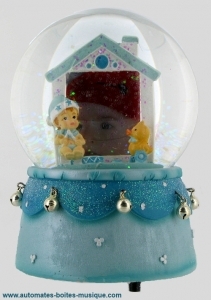 Schneekugel mit Spieluhr und neugeborenem Jungen.