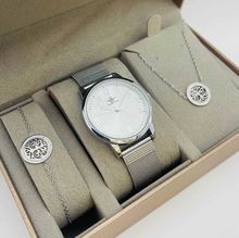 Coffret taupe d'une montre arrondie argentée et des bijoux en acier