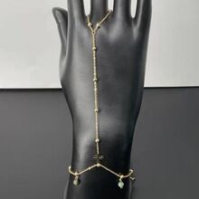 Bracelet bague orné de perles variées et d'un pendentif discret