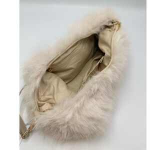 Sac en fausse fourrure porté à l'épaule avec une fermeture éclair
