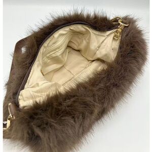 Sac en fausse fourrure porté à l'épaule avec une fermeture éclair