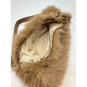 Sac en fausse fourrure porté à l'épaule avec une fermeture éclair