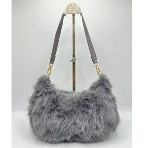 Sac en fausse fourrure porté à l'épaule avec une fermeture éclair