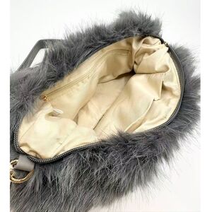 Sac en fausse fourrure porté à l'épaule avec une fermeture éclair
