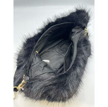 Sac en fausse fourrure porté à l'épaule avec une fermeture éclair