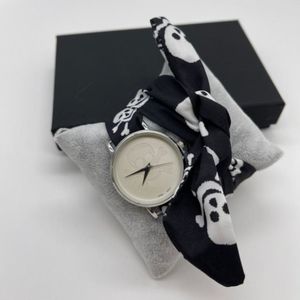 Montre en métal argenté et foulard avec motif tête de mort