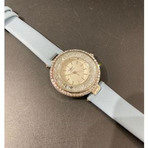 Montre dorée avec lunette rayonnante pavée de strass brillants
