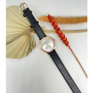 Montre ronde en métal doré rose et bracelet en simili cuir noir