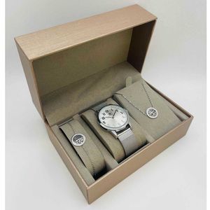 Coffret taupe d'une montre arrondie argentée et des bijoux en acier