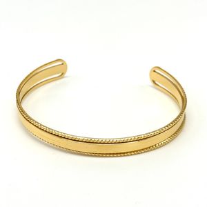 Bracelet Jonc ouvert en acier : bande lisse au centre, bordures texturées sur les côtés