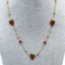 Collier fantaisie doré avec des breloques à motif fraise