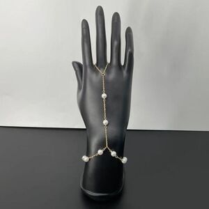 Bracelet bague en fine chaîne dorée orné des petites perles