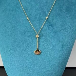 Collier sautoir avec un pendentif en forme de coquillage