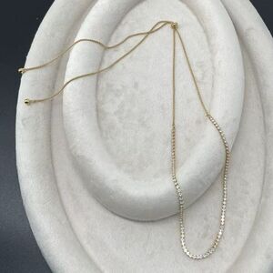 Collier doré orné d'une rangée de petites pierres transparentes