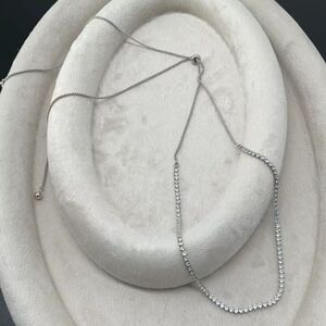 Collier argenté orné d'une rangée de petites pierres transparentes