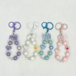 Dragonne de téléphone en perles avec nœud papillon, cœur et fleur pastel