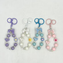 Dragonne de téléphone en perles avec nœud papillon, cœur et fleur pastel