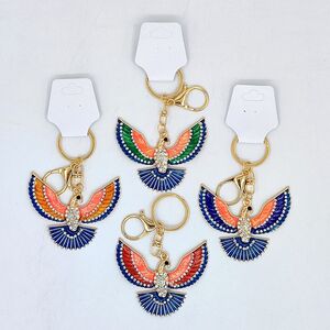 Porte-clés à pendentif oiseau en métal doré émaillé et orné de strass