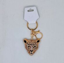 Porte-clés doré en tête de félin au design ajouré incrusté de strass