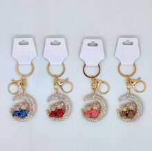 Porte-clés strassé en deux oursons assis sur un croissant de lune Doré