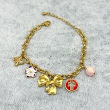 Bracelet en acier inoxydable doré à breloques ruban, fleurs et croix émaillée