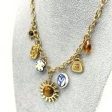 Collier en acier doré à maillons avec breloques sur un thème bohème-nature