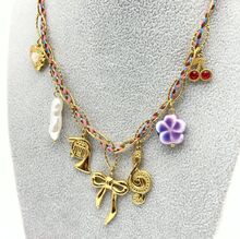 collier de chaîne dorée et fils colorés tressés enrichie de plusieurs breloques