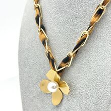 Collier à chaîne tressée d'un tissu léopard avec pendentif fleur orné d'une perle